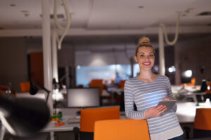 Foto jovem empresária trabalhando em tablet digital no escritório noturno